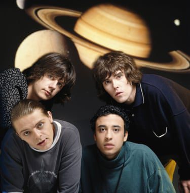 With an image of Saturn on the wall behind them, the band look to the camera.