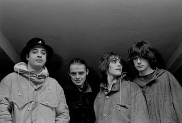 The band smile towards the camera, except Brown who looks to his left.