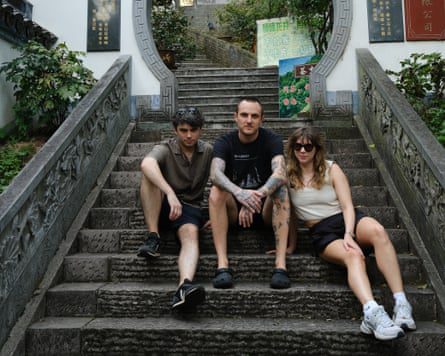 Three young British sit on some stairs in China.