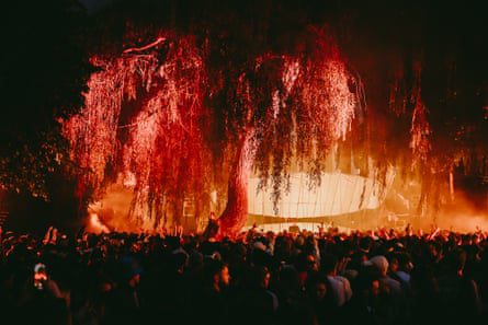 A crowd dancing under trees at night.